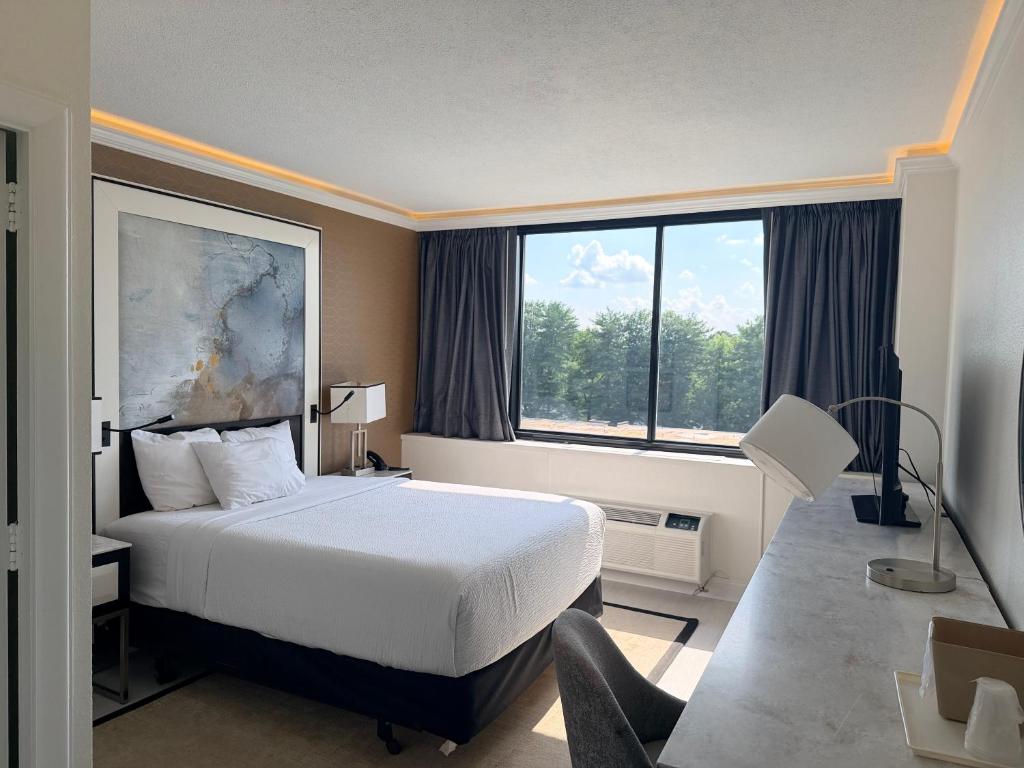 a hotel room with a bed and a large window at Inn at Lebanon - Hershey & Manheim area in Lebanon