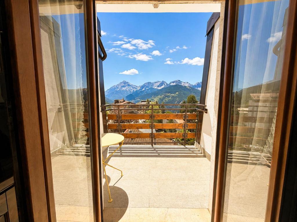 a balcony with a view of the mountains at Hostdomus - Villaggio Alpino in Sauze d'Oulx
