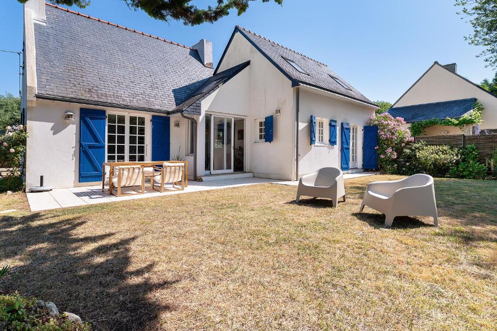 a white house with two chairs and a yard at Ker Family in Arzon
