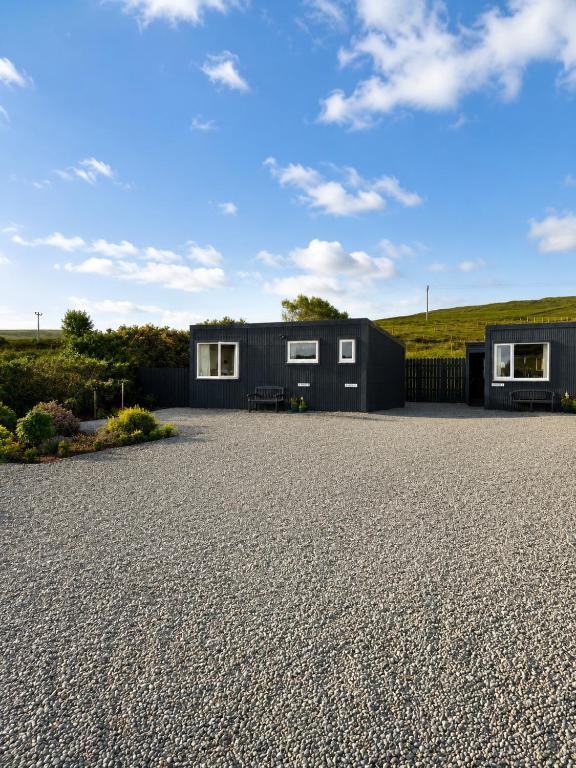 a black house with a gravel driveway at Minch View Cabin 1 in Earlish
