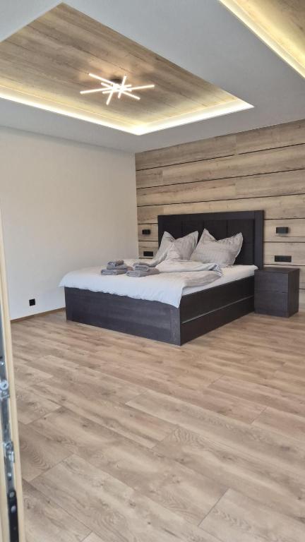 a bedroom with a large bed and a ceiling at Villa White Stone in Starý Smokovec