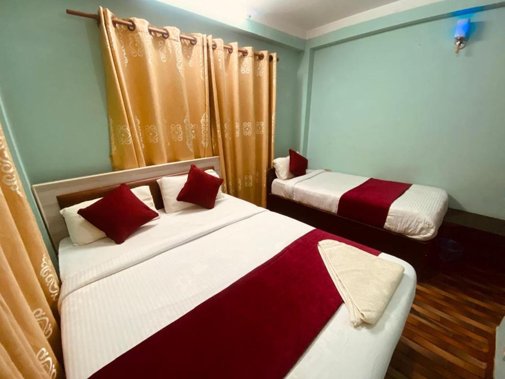 a bedroom with two beds with red and white at Hotel New Bhojpure in Kathmandu