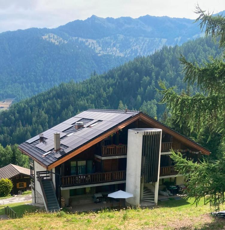 a house on a hill with mountains in the background at Mountain Studio in La Tzoumaz