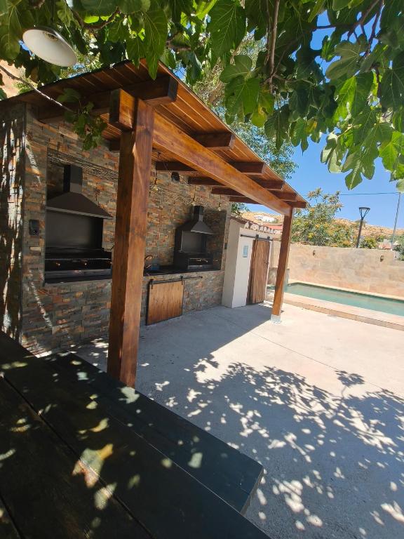 a brick oven with a wooden roof on a patio at Cuevas Uropia in Graena