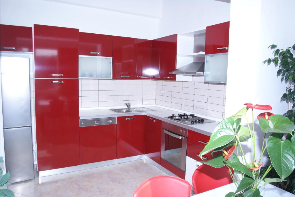 uma cozinha vermelha com um frigorífico de aço inoxidável e armários vermelhos em Apartment Jasovic em Korčula