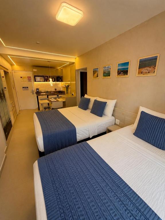 a hotel room with two beds and a kitchen at MERCURE RECIFE NAVEGANTES · Flat Recife Navegantes - 50 metros da praia. in Recife