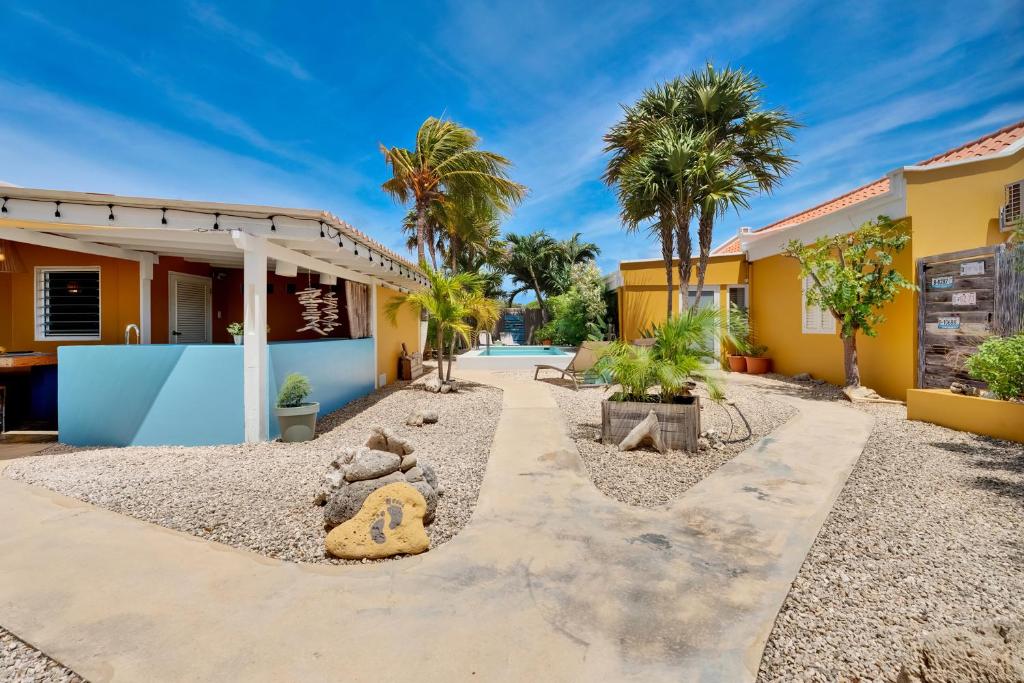 a house with a courtyard with palm trees at Barefoot Bonaire in Kralendijk