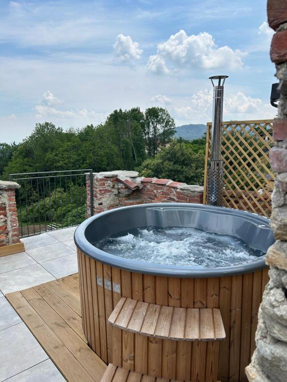 a hot tub on a deck with a bench at Da Noi Panoramic Guest Stay Camera Rifugio in Cuorgnè