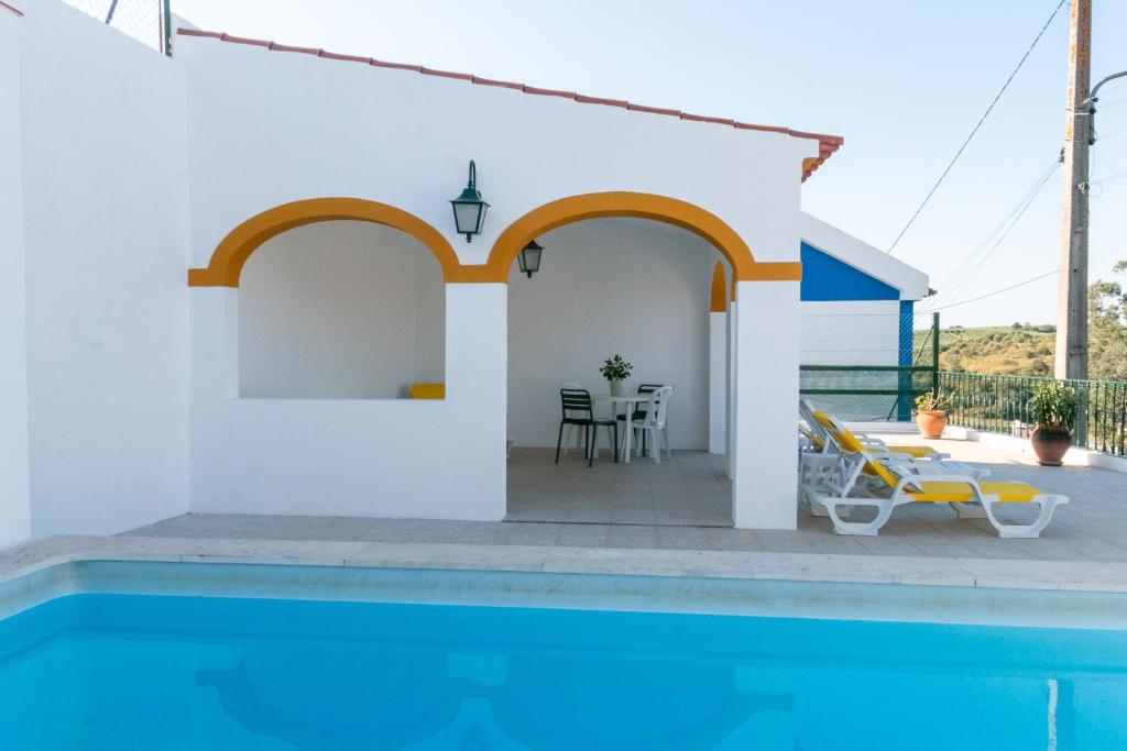 a villa with a swimming pool and a patio at Casa dos Alpendres in Avis