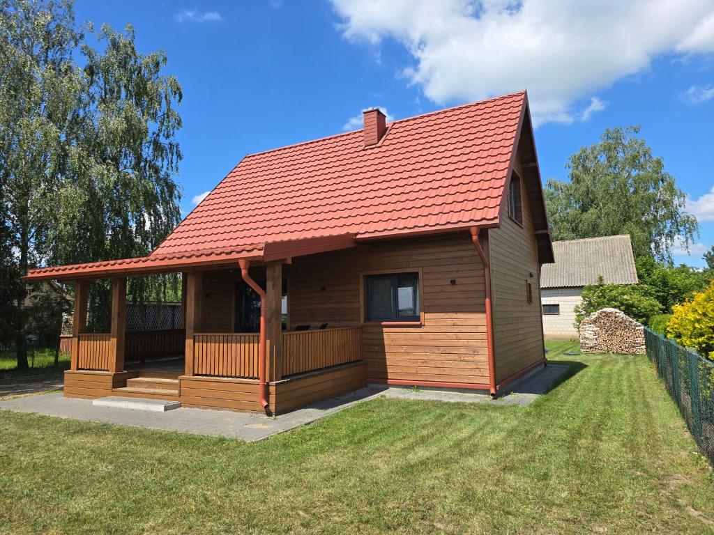 a log cabin with a red roof at Dolina Biebrzy - Siedlisko Wroceń 57 in Wroceń