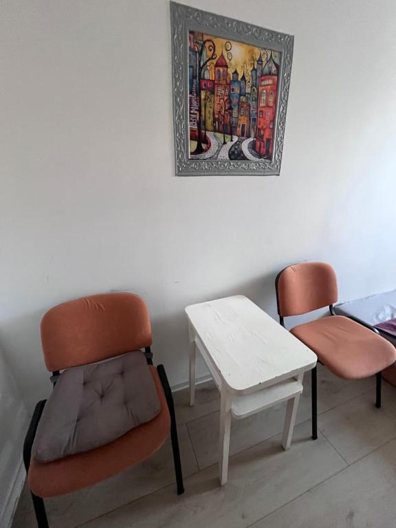 two chairs and a table and a picture on the wall at Single Room Old Town in Košice