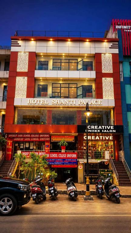 a hotel with motorcycles parked in front of a building at Hotel shanti palace in Agra
