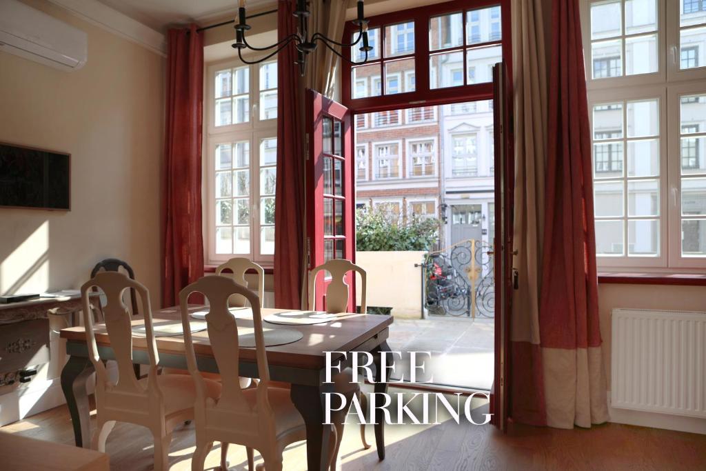 a dining room with a table and chairs and a large window at Patio Apartments - Old Town in Gdańsk