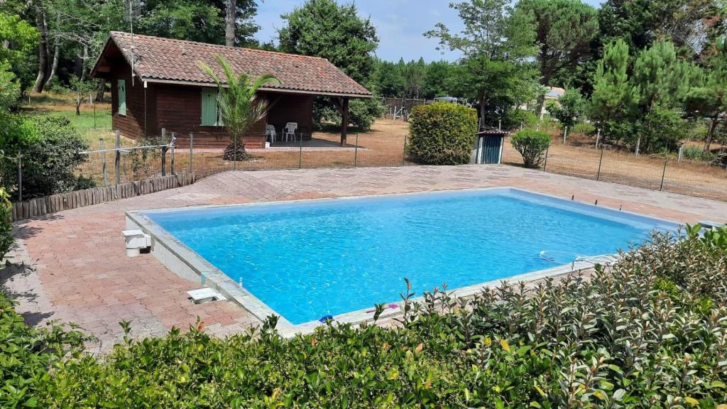 a swimming pool in front of a house at Chalet Saint Julien en Born in Saint-Julien-en-Born