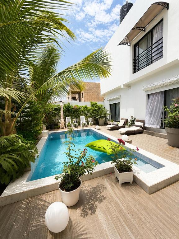 a swimming pool in the backyard of a house at Le Refuge du Lac Rose in Ouayembame