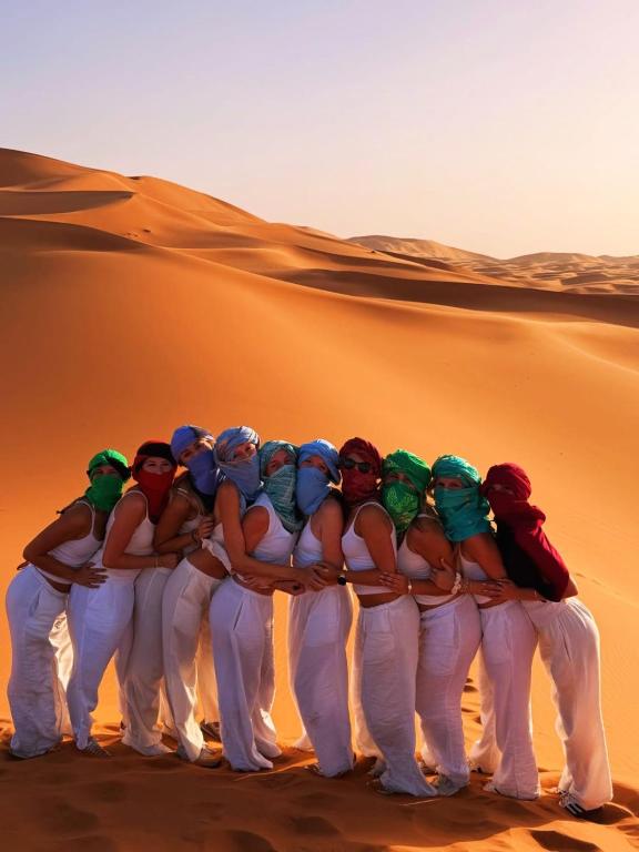 a group of women standing in the desert at Pulse Desert Camp in Merzouga
