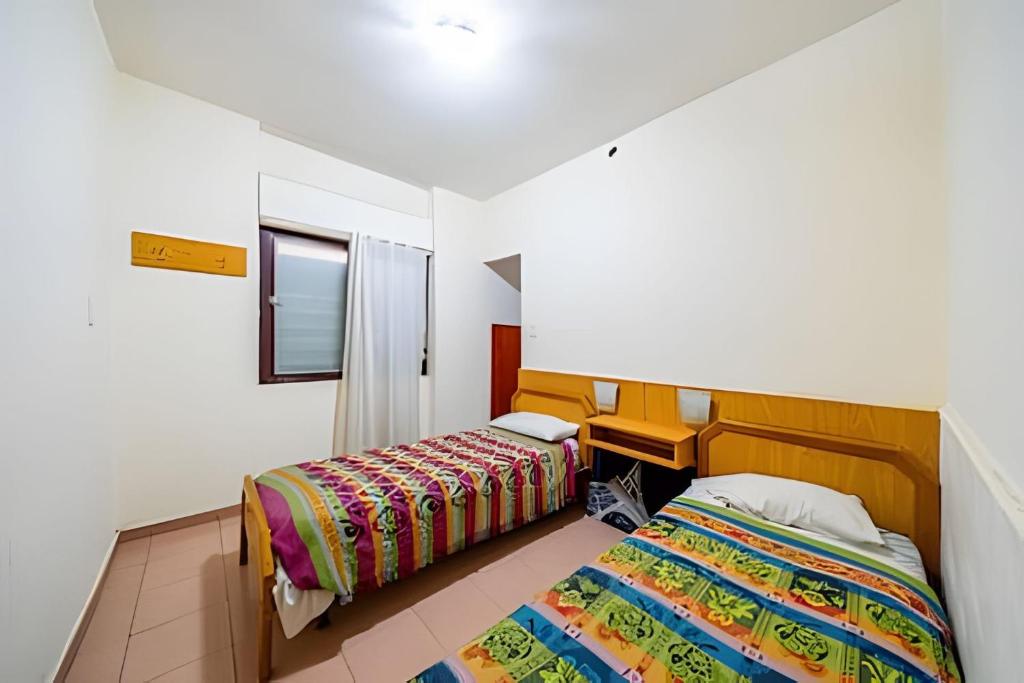 a bedroom with two beds and a window at "Alpha", downtown hotel room in Rosario