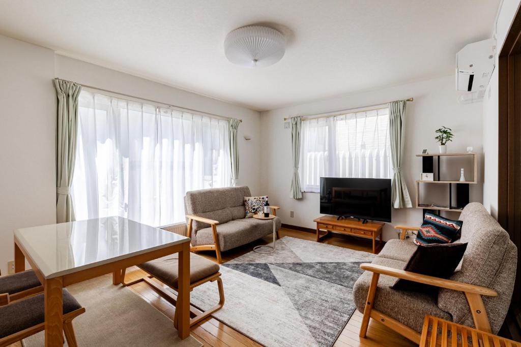 a living room with a table and chairs at つぐ屋札幌 in Sapporo