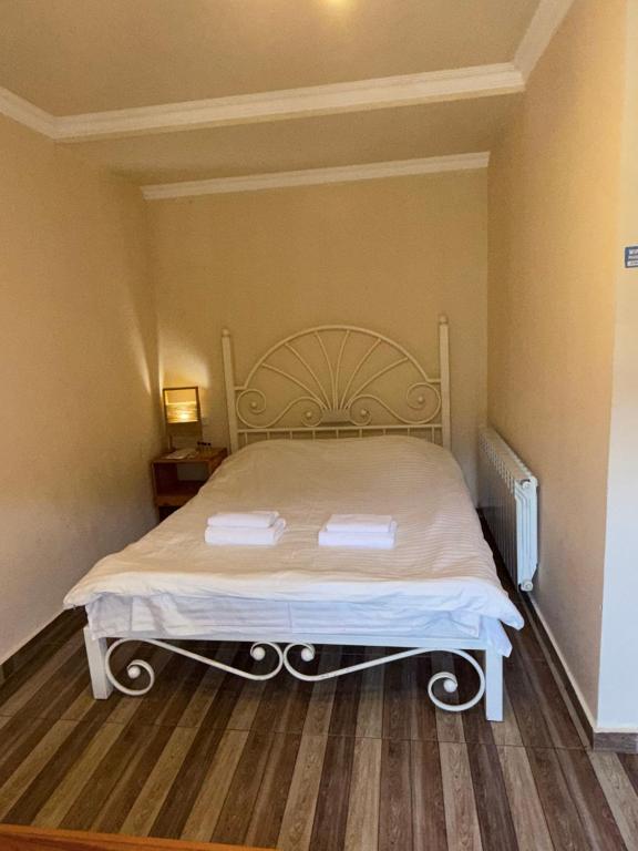 a large bed in a room with a wooden floor at Arami Guest House in Dilijan