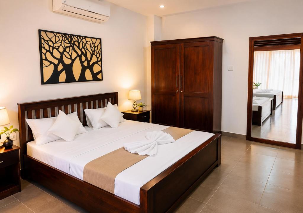 a bedroom with a large bed and a bathroom at Ravan Safari Rest Inn in Udawalawe