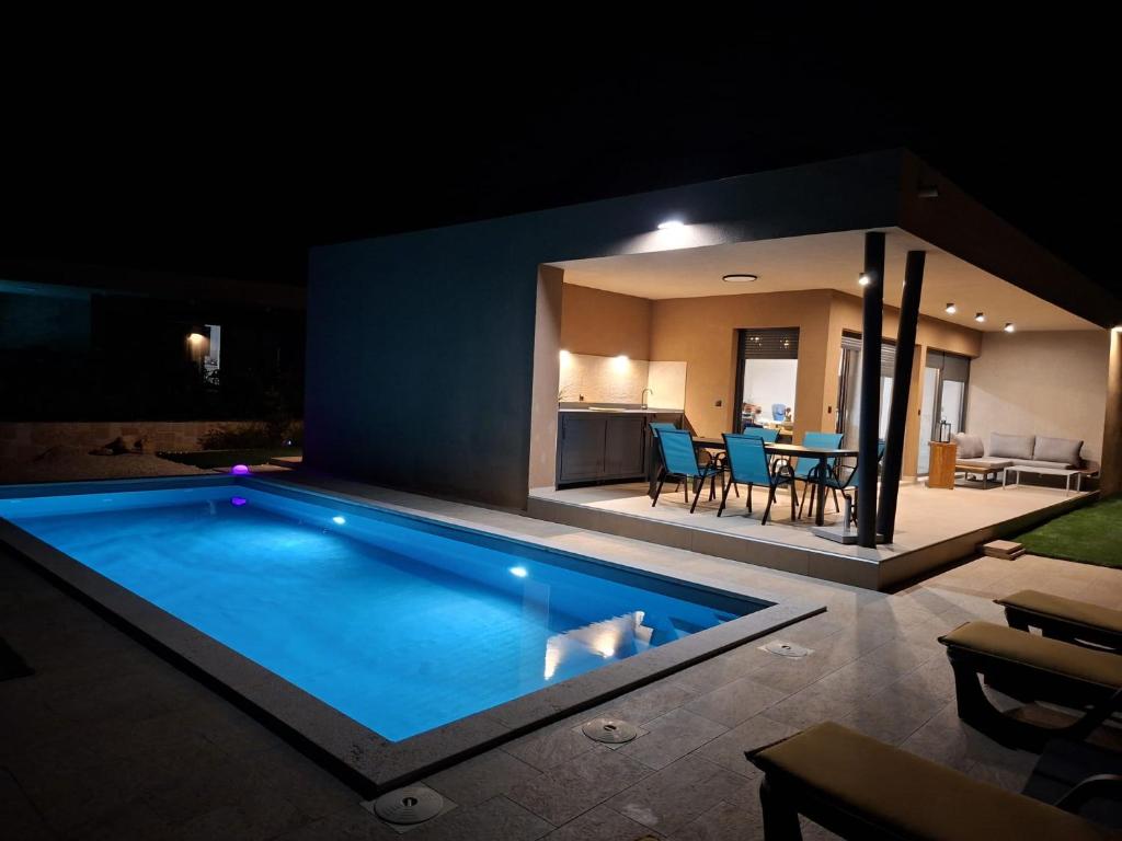 a swimming pool in a backyard at night at Vila Mila Private Pool Retreat in Radetići