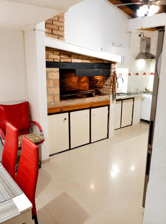 a kitchen with white cabinets and a brick wall at Casa Solymar completa 3 dormitorios 5 camas Hasta 6 personas RESERVAS SOLO CON SEÑA in Ciudad de la Costa