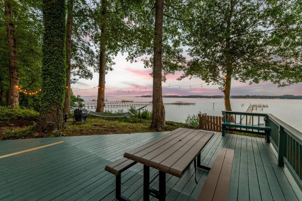 a wooden bench sitting on a deck next to a lake at Scenic, Spacious Riverside Retreat Ropeyarn in Deltaville