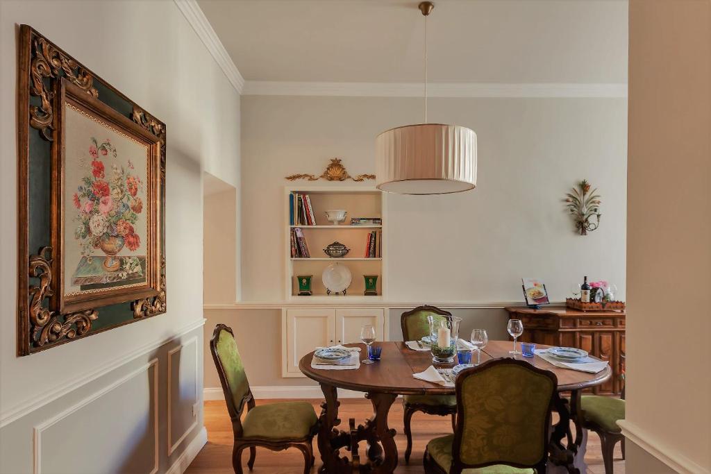 uma sala de jantar com mesa e cadeiras em Unione Charme em Florença