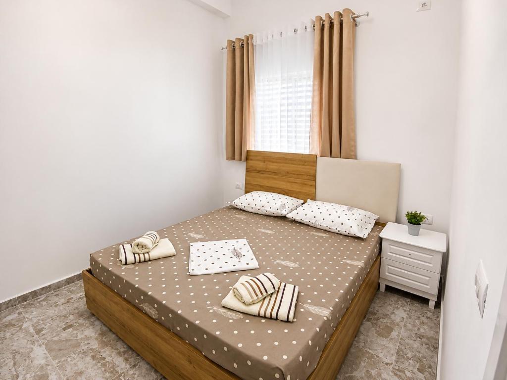 a small bedroom with a bed and a window at GUGA Host House in Sarandë