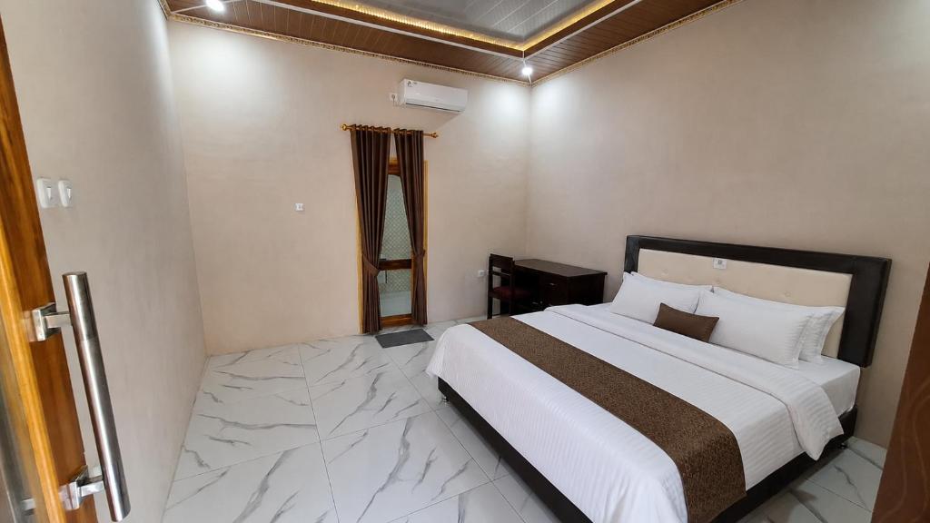 a bedroom with a large white bed in a room at Homestay Sadikin Scar Reef Beach Jelenga in Maluk