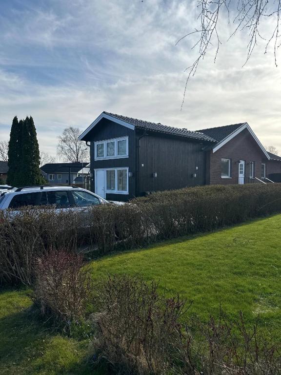 a house with a car parked in front of a yard at Happy stay apartment in Vallda