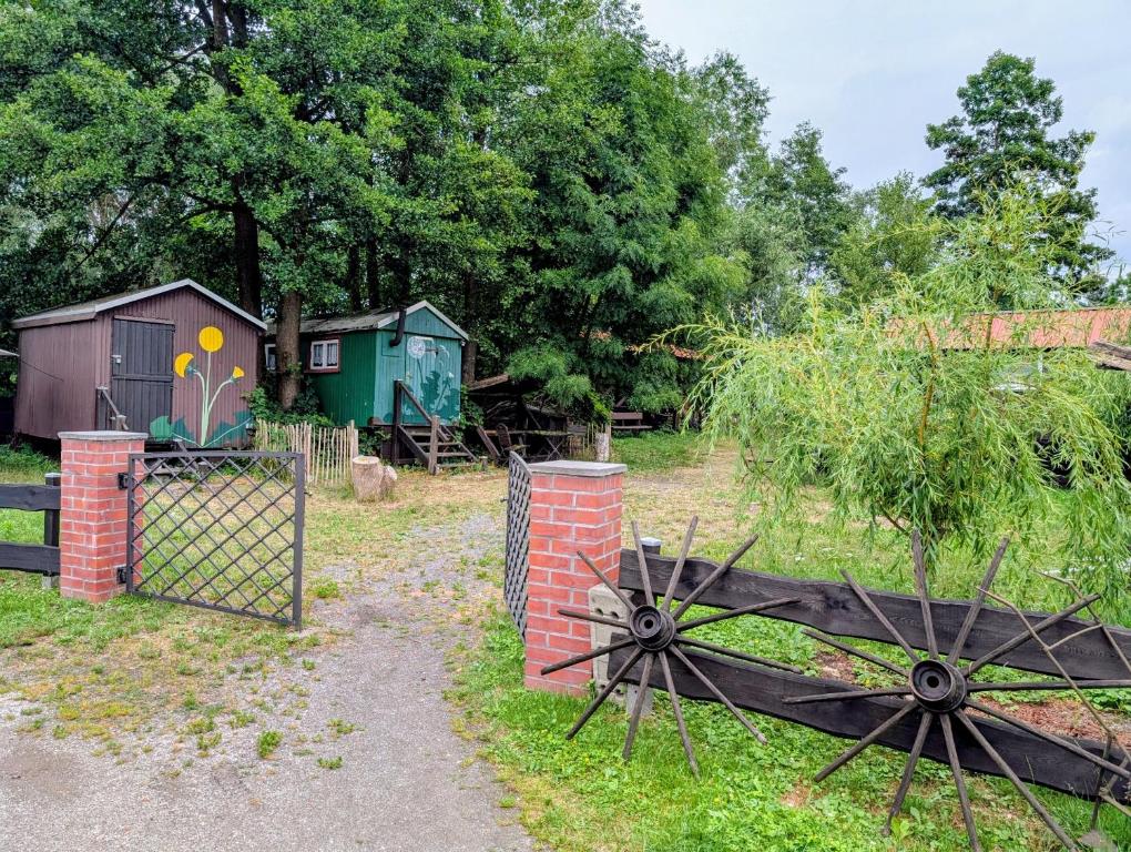 a garden with a fence and a gate and a barn at Radler-Pension in Lübbenau