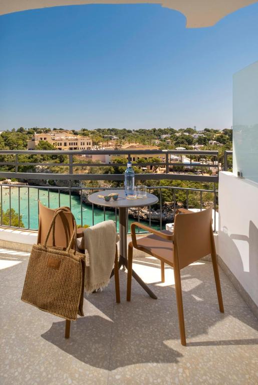 a table and chairs on a balcony with a view at Cabot Cala Ferrera in Cala d´Or