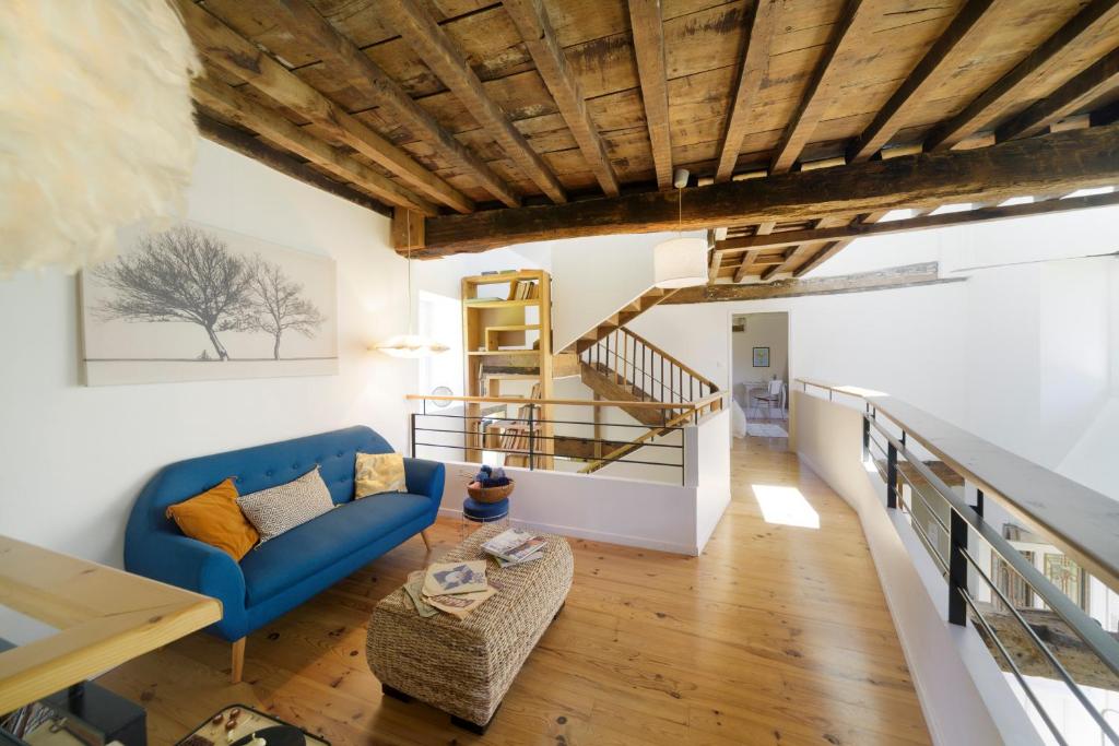 a living room with a blue couch and a staircase at Chez Castagné in Issor