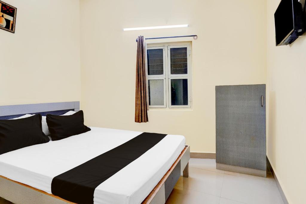 a bedroom with a bed and a window at Hotel O Bluestar in Bangalore