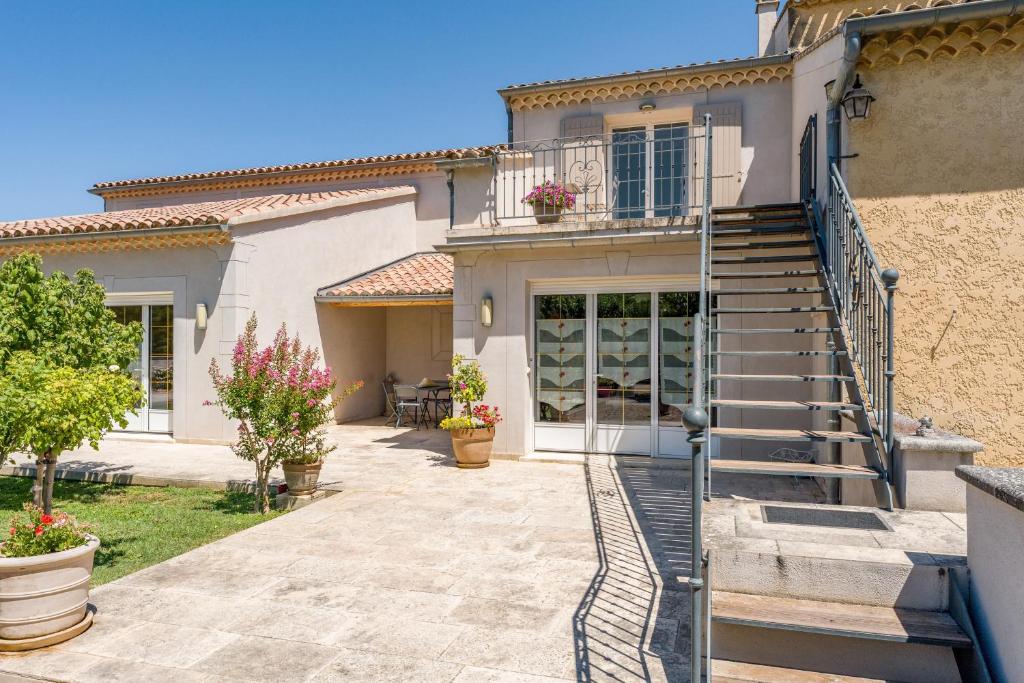 a house with a staircase leading to the front door at La Bastide Des Mereuilles in Orange