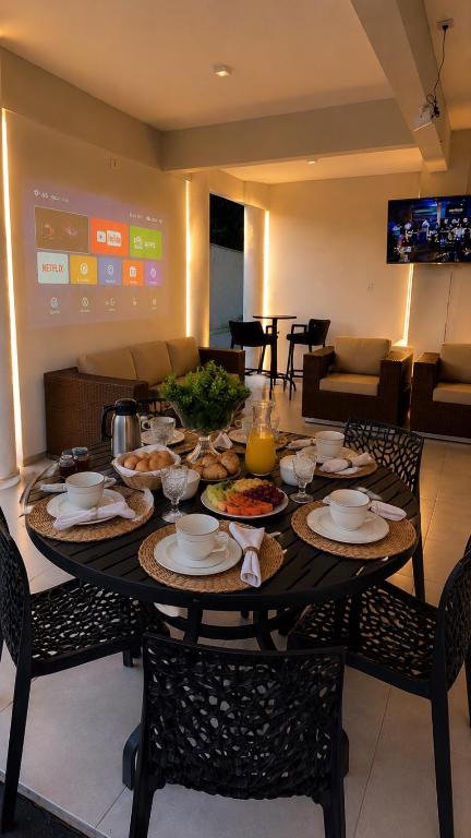 a dining room table with plates and food on it at Recanto Veraneio - Londrina in Londrina
