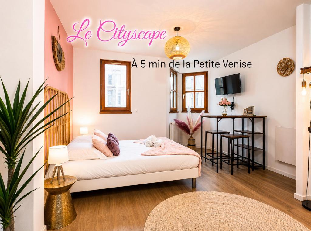 a bedroom with a white bed and a table at Nouveau - Le CityScape - Petite Venise in Colmar