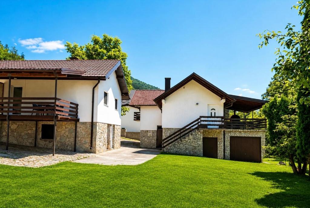 a house with a green lawn in front of it at holiday home RIVER HOUSE in Jajce