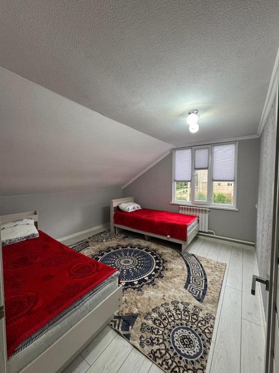 a room with two beds and a red couch at Ademi Guest House in Kochkorka