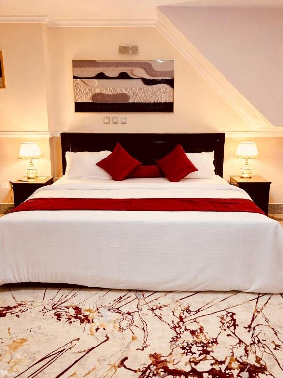 a bedroom with a large white bed with red pillows at The Castle Private Villa in Aso