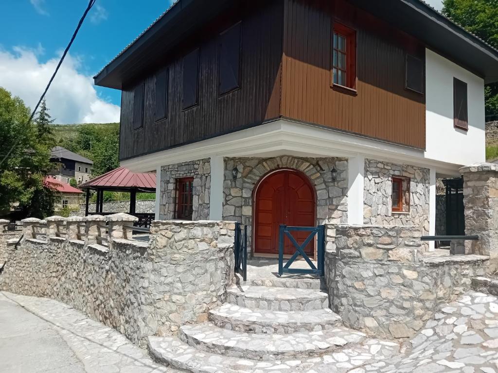 a house with a red door and a stone wall at Villa Galicnik in Galičnik