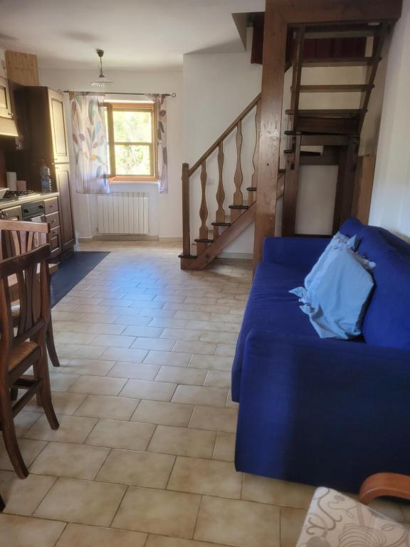 a living room with a blue couch and a staircase at I 23 PASSI Alfedena in Alfedena