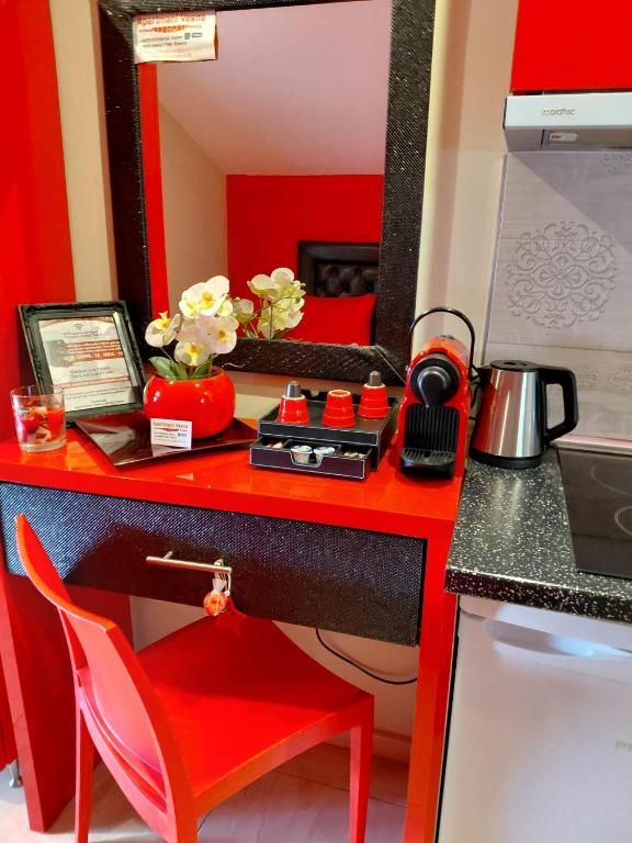 a red desk with a red chair and a mirror at Apartments Vesna Luxury ap 5 & 6 Paralia in Paralia Katerinis
