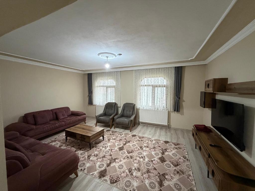 a living room with a couch and chairs and a television at Kır Home in Çaykara