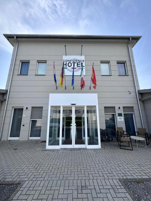 a white building with flags in front of it at Confidence Hotel Viadana in Viadana