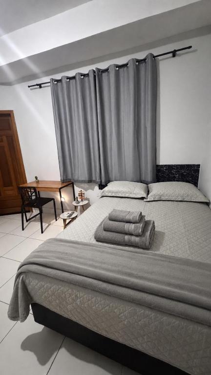 a bedroom with a large bed with towels on it at Sobrado Tropical a 1 Km da faculdade Unic e UFMT in Cuiabá