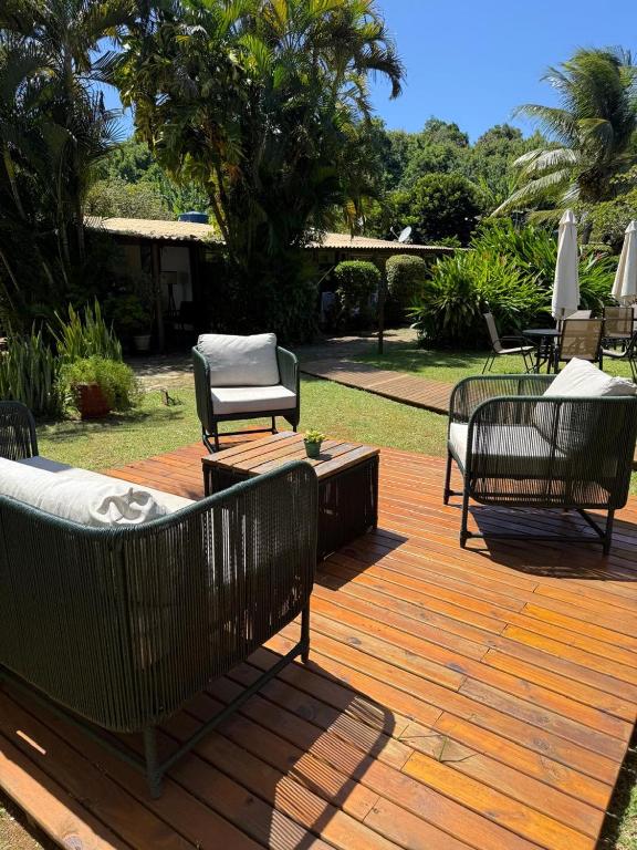 a wooden deck with chairs and a table and chairs at Pousada Cheiro Verde Noronha in Fernando de Noronha