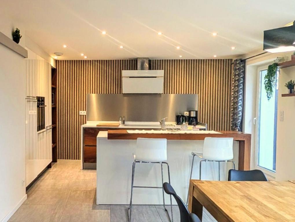 a kitchen with a counter and stools in a room at La Chataigneraie in Châtenois