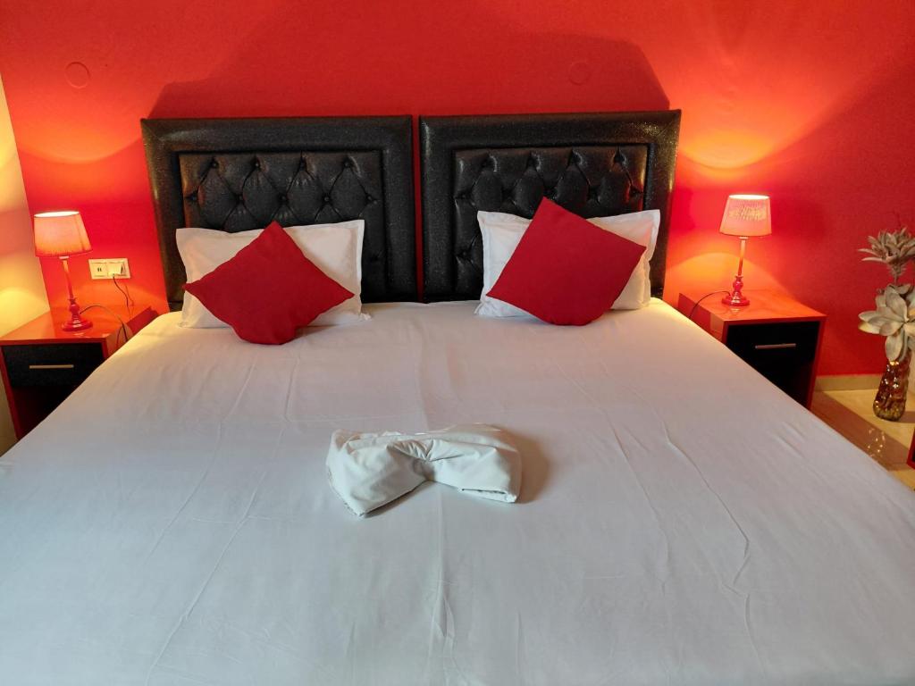 a bedroom with a white bed with red walls at Apartments Vesna Luxury & Stefan ap 4 in Paralia Katerinis